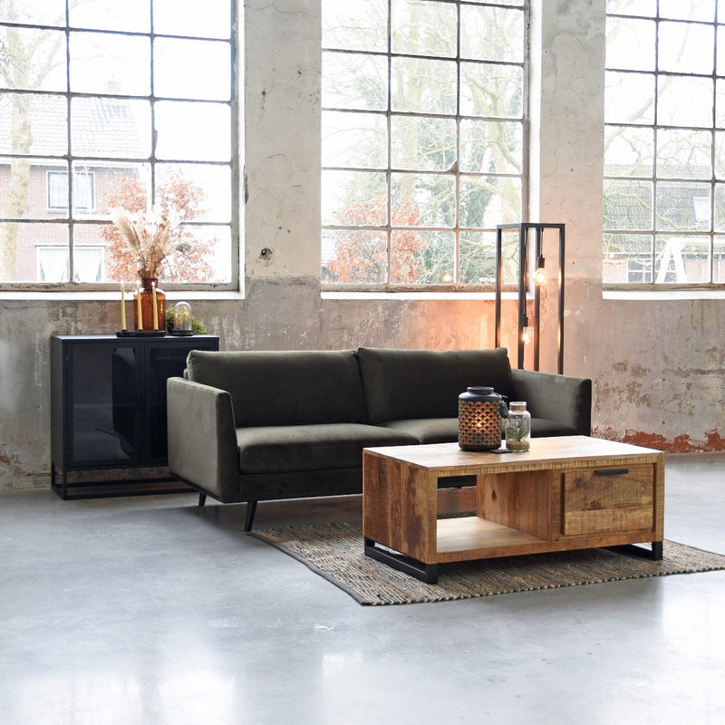 Canapé design 3 places en velours vert idéal pour un salon de style industriel.